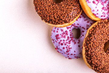 Assorted delicious donuts on light marble background
