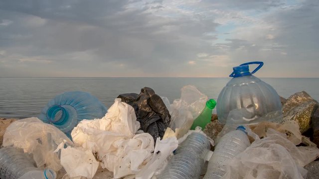 Timelapse. Plastic bottles in a polluted. Clouds background