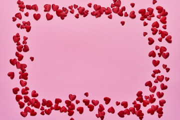 Valentines Day background. Border of red hearts on pink background. Copy space, top view.