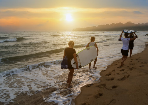 surfers running sea surf boards