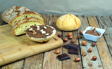 bread with chocolate cream and nuts on a wooden background, nutella