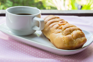 Appetizing bread and cup of coffee on table