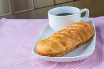 Appetizing bread and cup of coffee on table