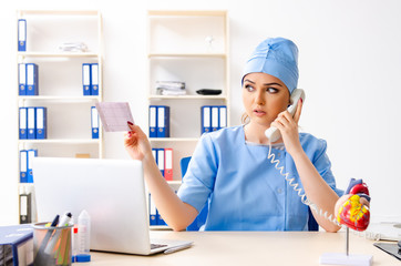 Young female doctor cardiologist sitting at the hospital 
