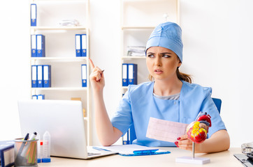 Young female doctor cardiologist sitting at the hospital 