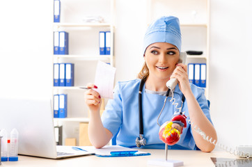Young female doctor cardiologist sitting at the hospital 