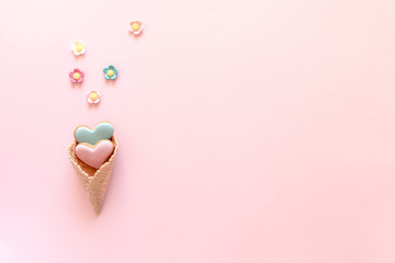 Valentine's day background. Ice cream waffle cone with ginger cookie in shape heart on pink background. Valentine day concept, design. Flat lay, top view, copy space