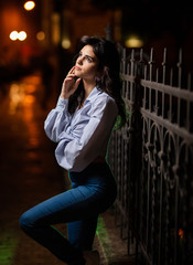 Attractive woman walks through the city at night