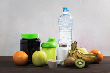 shaker with bananas, oranges, kiwi and apples, mineral water on the wooden table