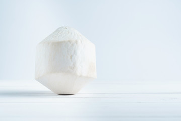 Tropical drinking coconut on white wood background.