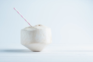 Coconut with a straw isolated on white background.
