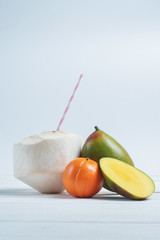 Fototapeta na wymiar Drinks coconut with straw, mango and mandarin.