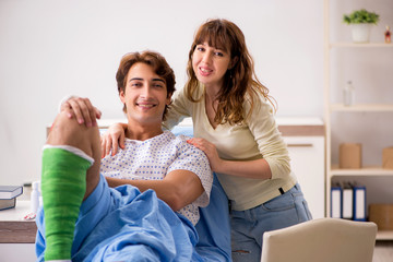 Fototapeta na wymiar Loving wife looking after injured husband in hospital 