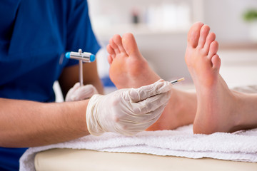 Podiatrist treating feet during procedure