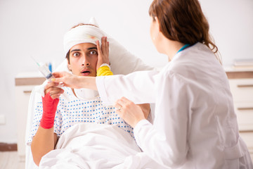 Young doctor examining injured patient 