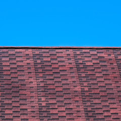 Fototapeta na wymiar Roof from multi-colored bituminous shingles. Patterned bitumen s