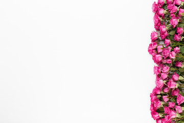 Flowers composition. Frame made of red rose on white wooden background. Flat lay, top view, copy space.