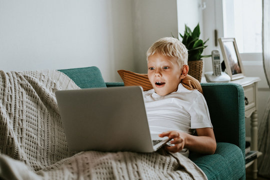 Young boy watching videos on his laptop