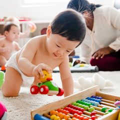 Baby playing with a wooden car