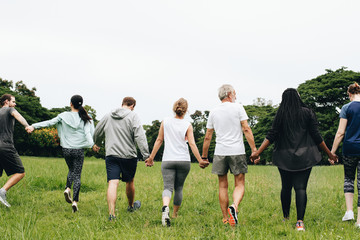 Group of adults holding hands in the park