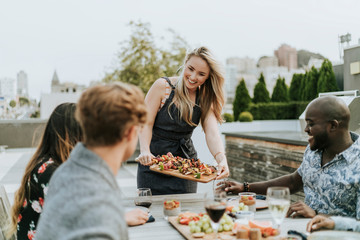 Woman serving vegan barbecue to her friends - obrazy, fototapety, plakaty