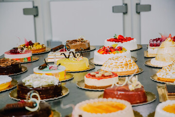 many cakes prepared on the metal table of a food factory