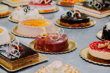 many cakes prepared on the metal table of a food factory