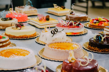 many cakes prepared on the metal table of a food factory