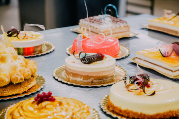 many cakes prepared on the metal table of a food factory