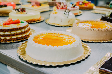 many cakes prepared on the metal table of a food factory