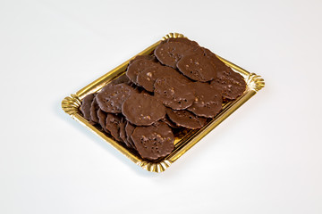 chocolate cookies in a gold tray on white background