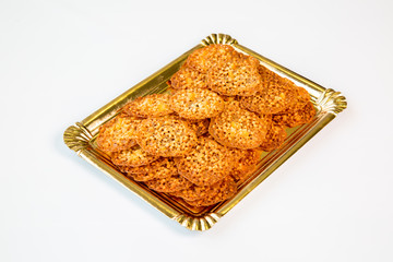 crunchy almond cookies in a gold tray on white background