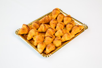 croissants in a gold tray on white background