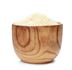 Bowl with uncooked rice on white background