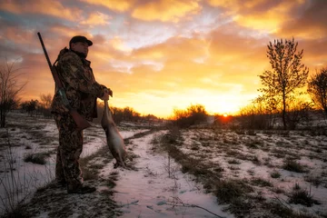 Photo sur Plexiglas Chasser Chasse d& 39 hiver. Hunter se déplaçant avec Shotgun et lièvre dans ses mains.