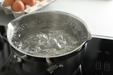 Pot with boiling water on stove, closeup
