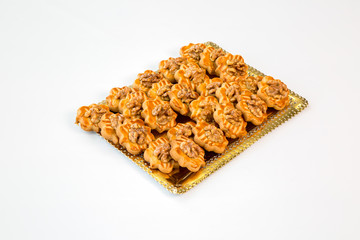 nut cookies on a gold tray with white background