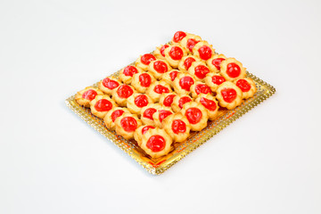 cherry cookies on a gold tray with white background