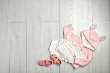 Flat lay composition with cute clothes and space for text on wooden background. Baby accessories