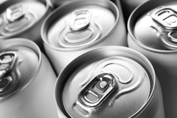 Aluminum cans with cold beverage as background, closeup