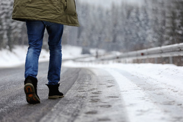 Man walking outdoors on snowy winter day. Space for text