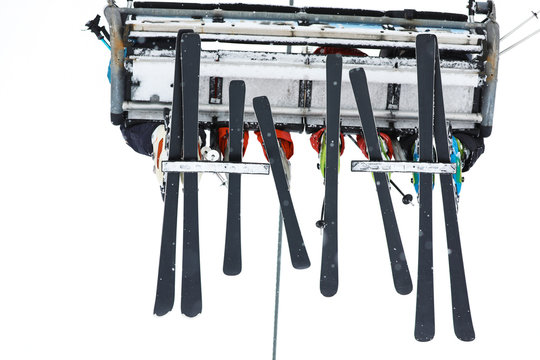 People using ski lift at mountain resort, bottom view. Winter vacation