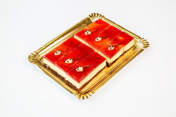 cheesecake portions on a gold tray on white background
