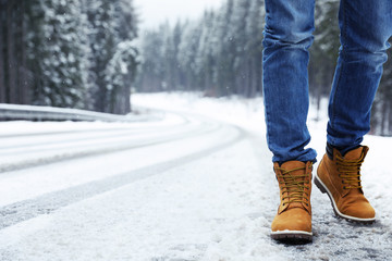 Man walking outdoors on snowy winter day. Space for text