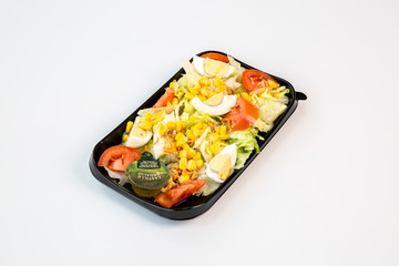 salad on a black tray with white background