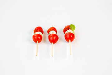 cherry tomatoes and mozzarella on a stick with white background