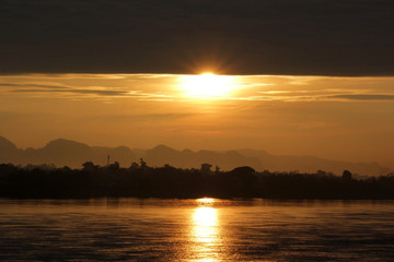 early morning on the river with silhouette mountains and tree