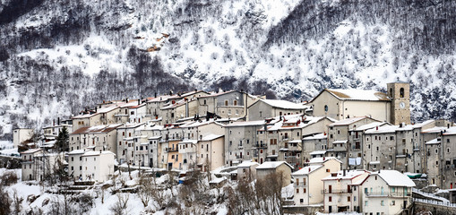 Aerial view of the beautiful snow-covered village of Opi with snow-capped mountains in the background. Opi is a comune and town in the province of L'Aquila in the Abruzzo region of central Italy.