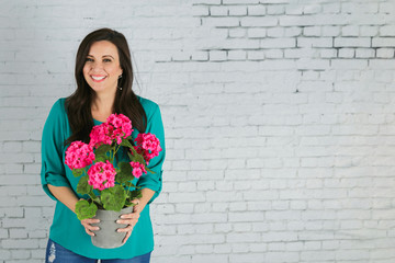 Beautiful Hispanic Woman Holding a pot of Pink Spring Flowers