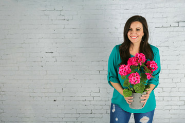 Beautiful Hispanic Woman Holding a pot of Pink Spring Flowers